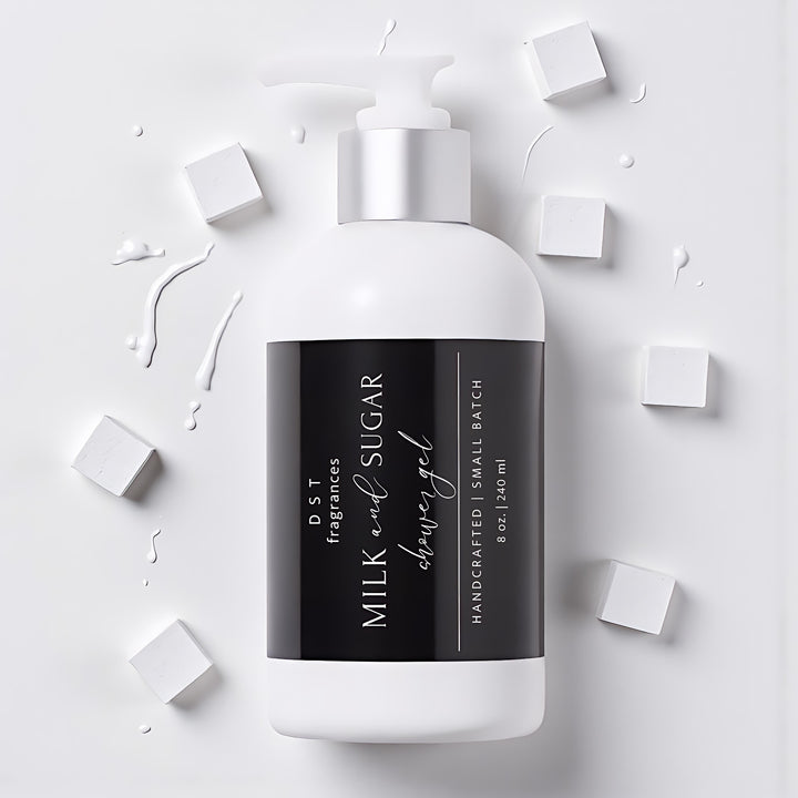 240ml bottle of Milk and Sugar Scented Shower Gel by DST Fragrances laying on a light grey surface with splashes of white milk and white sugar cubes surrounding the bottle.