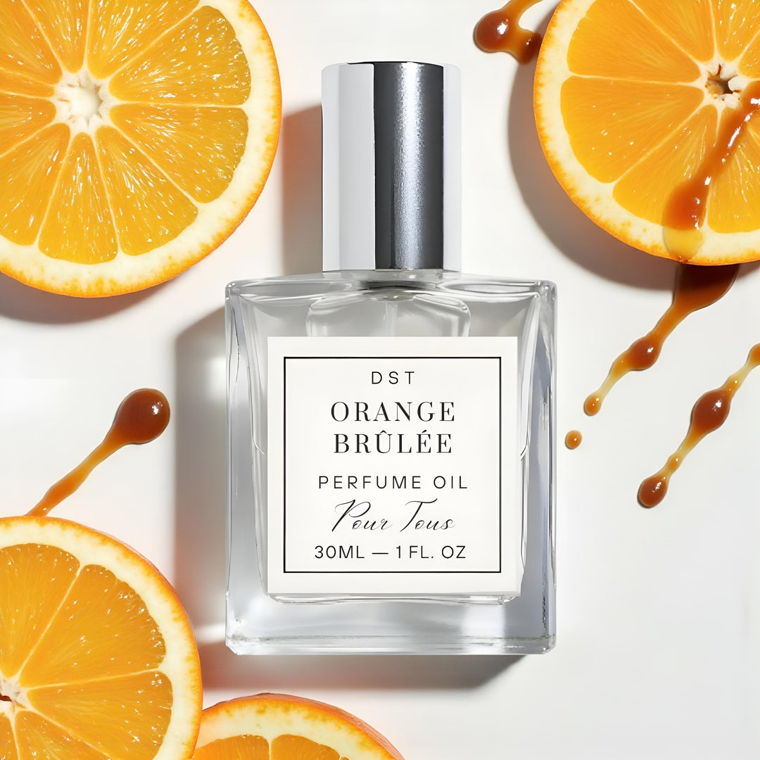 Perfume oil bottle labeled 'Orange Brèlé' with orange slices and syrup on a white background