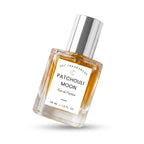 A 30 ml bottle of DST Fragrances Patchouli Moon Eau de Parfum, featuring a clear glass bottle filled with amber-colored liquid, a white label, and a reflective silver cap, shown on a white background with a soft shadow.