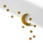 Gold crescent moon and star wall decor arranged diagonally on a white background with soft shadows.