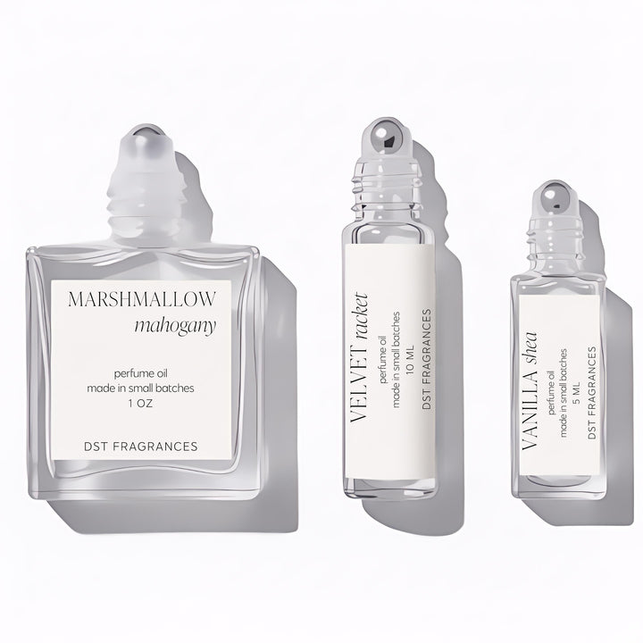 Three capless perfume bottles of Perfume Oil from DST Fragrances in 5ml, 10ml, and 30ml sizes meant to show size comparison and roller ball dispenser on a white background.