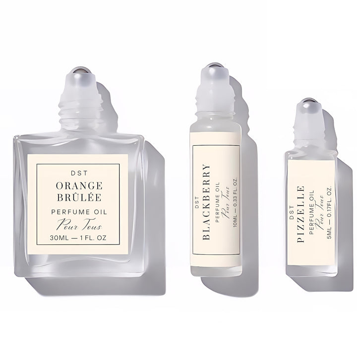 Three roll-on perfume oil bottles with labels on a white background
