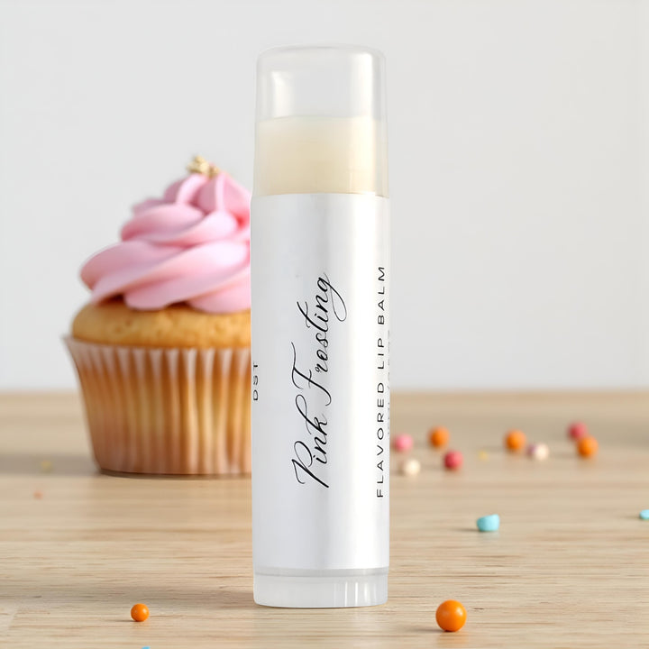 Lip balm labeled 'Pink Frosting' with a cupcake in the background