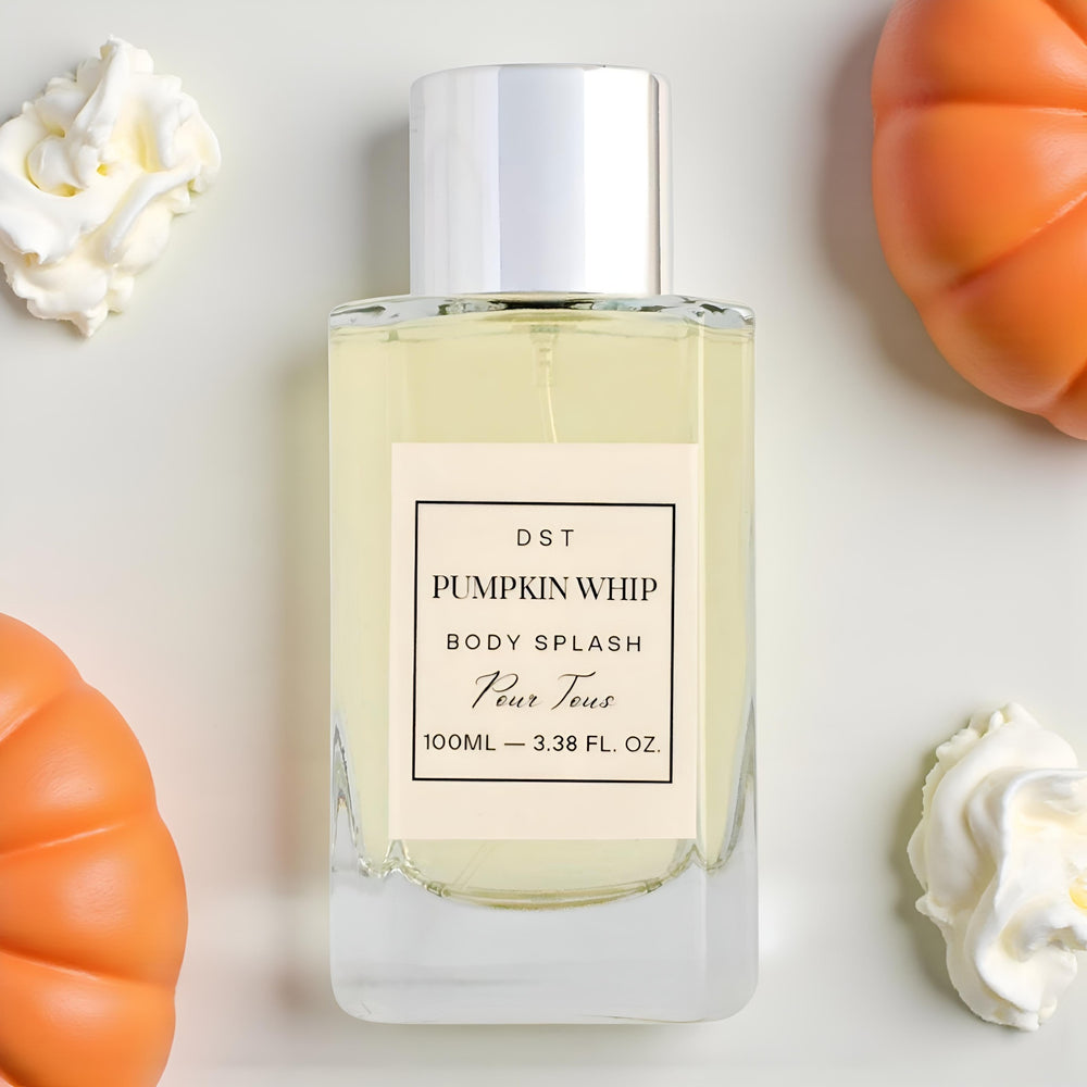 Bottle of 'Pumpkin Whip' body splash with decorative pumpkins and whipped cream on a light background