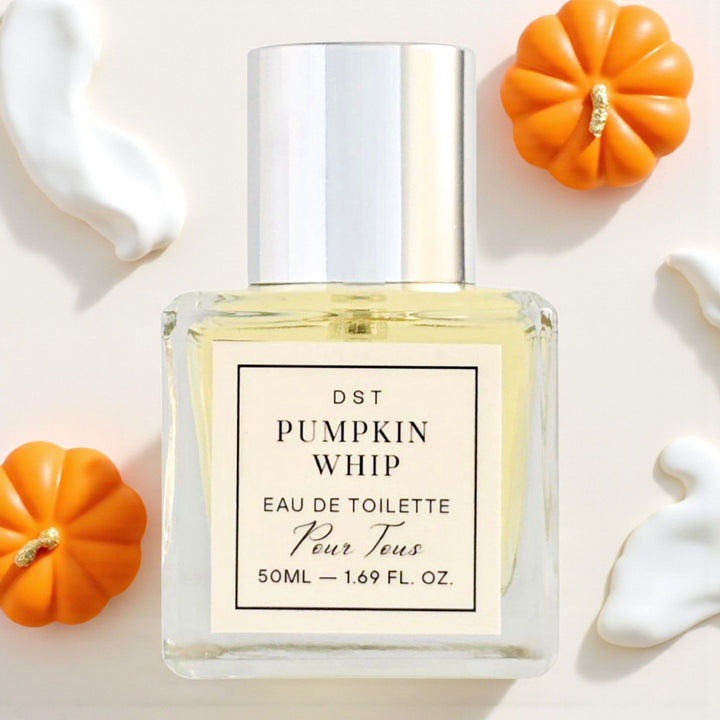 Perfume bottle labeled 'Pumpkin Whip' with small pumpkins on a light background