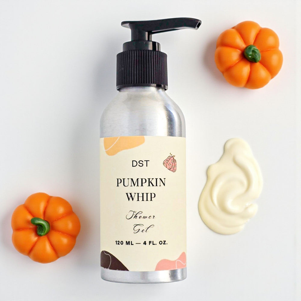 Bottle of DST Pumpkin Whip Shower Gel with pump, pumpkins, and cream on a light background