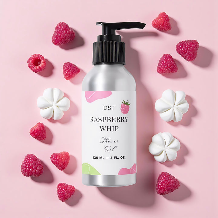 Shower gel bottle labeled 'Raspberry Whip' with packaging and a cupcake on a pink background