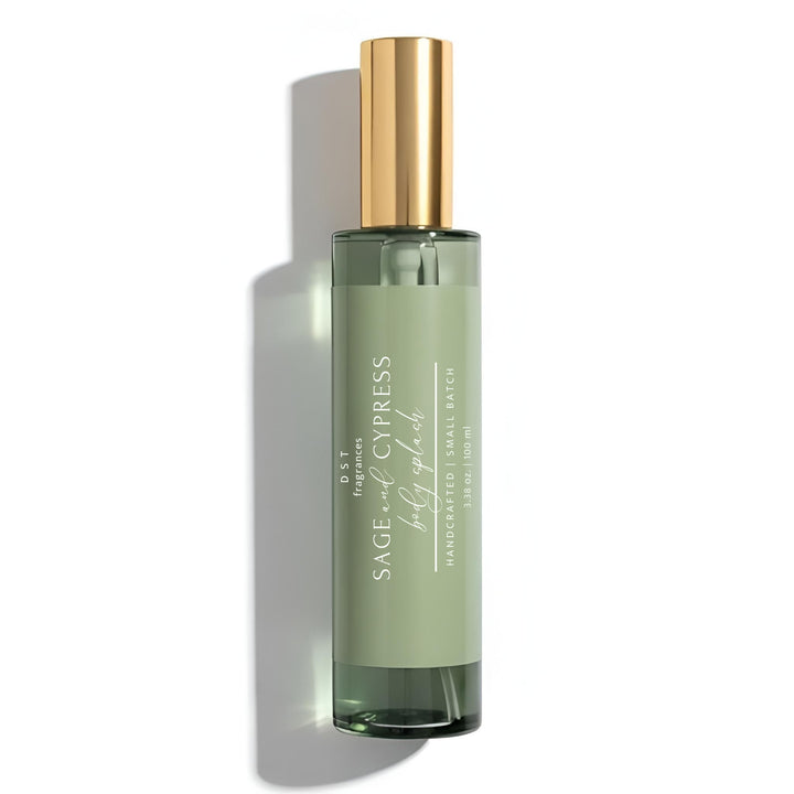 Green bottle of Sage and Cypress Body Splash with gold cap on a white background