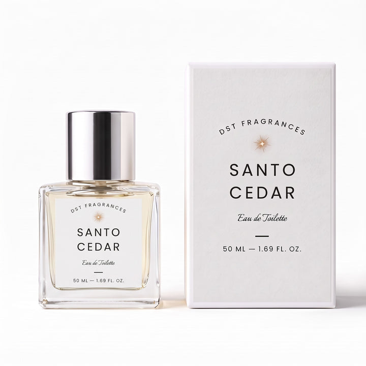 A clear glass bottle of Santo Cedar Eau de Toilette fragrance with a reflective silver cap stands next to its white packaging box. The label and box display the brand name DST FRAGRANCES and the scent name SANTO CEDAR.