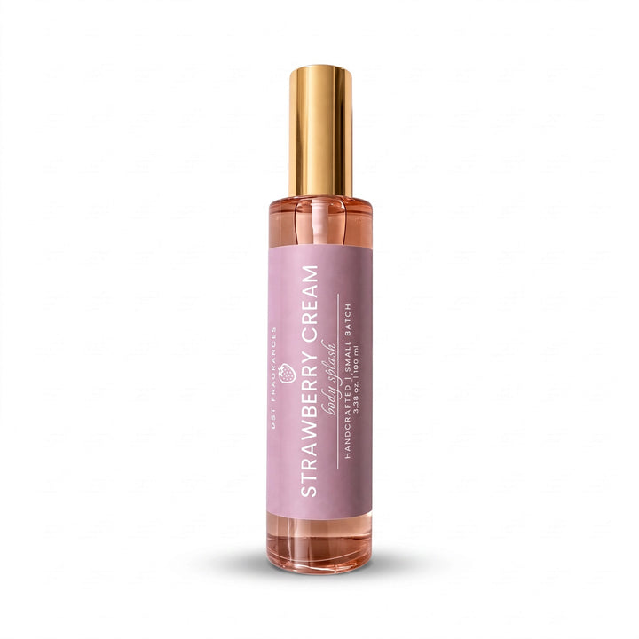 A clear glass spray bottle filled with pink liquid, featuring a lavender label that reads &