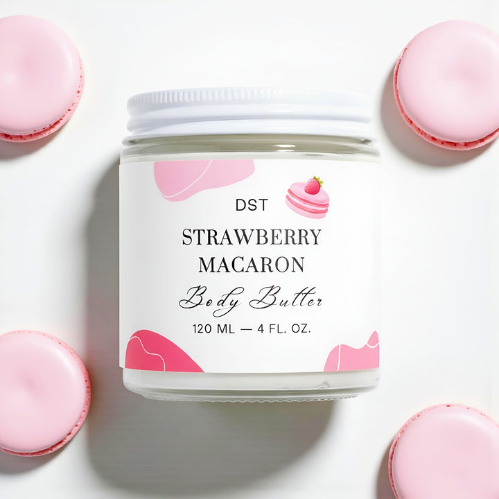 Jar of strawberry macaron body butter with pink macaron cookies on a white background