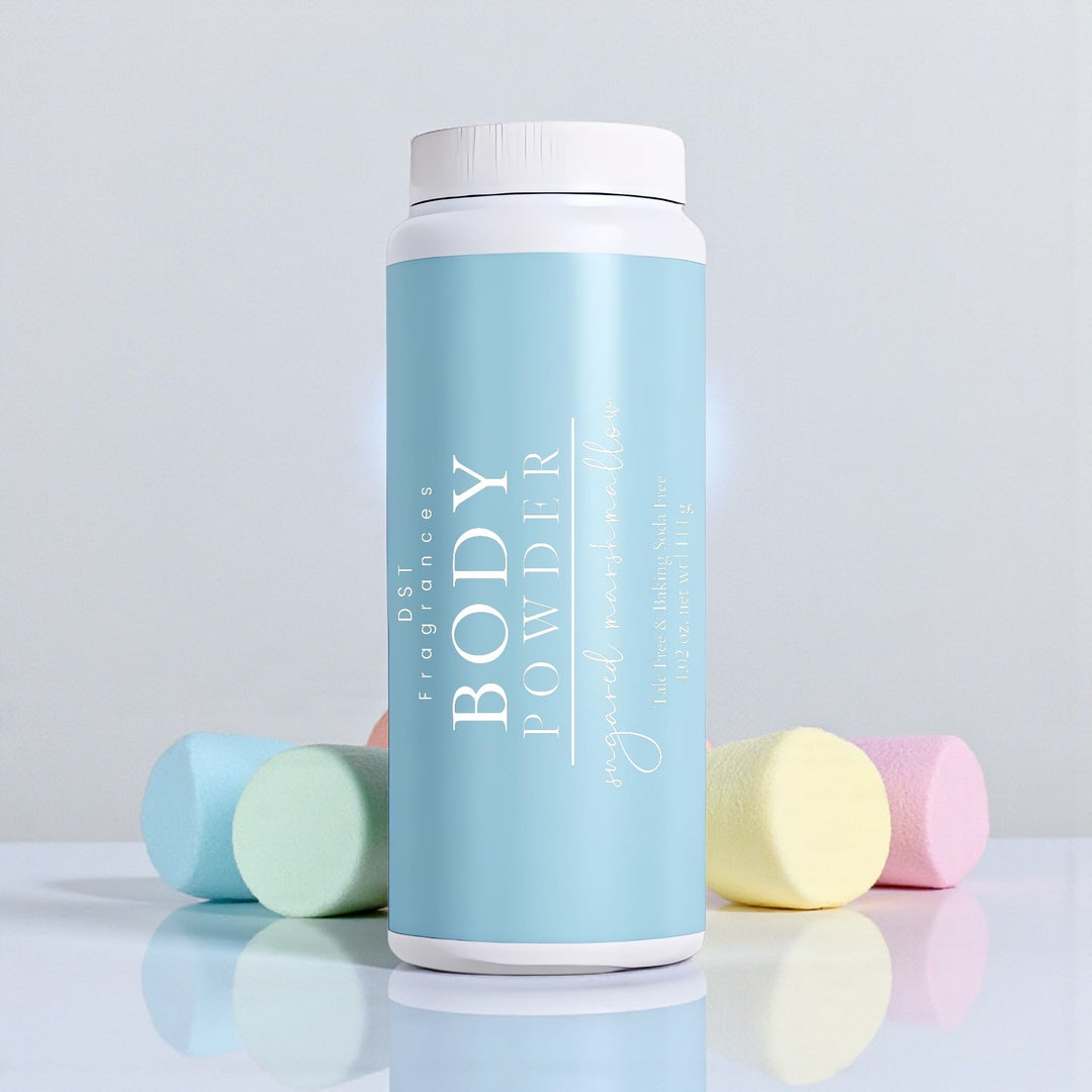114G bottle of Sugared Marshmallow scented Body Dusting Powder by DST Fragrances sitting on a shiny white surface with pastel colored marshmallows in the background.