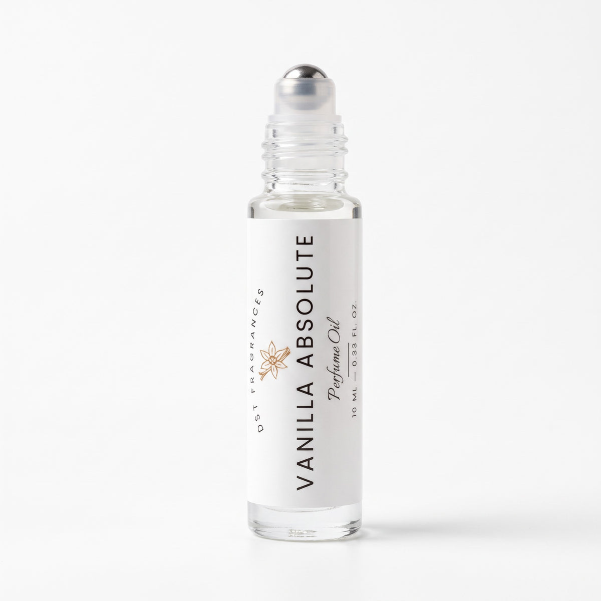 A 10 mL clear glass rollerball bottle of Vanilla Absolute perfume oil by DST Fragrances, featuring a white label with black text and a small gold starburst logo, topped with a silver cap, set against a clean white background.