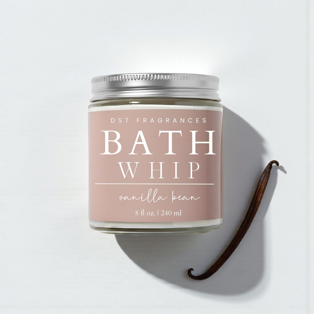 Vanilla bean bath whip container with vanilla beans on a light background