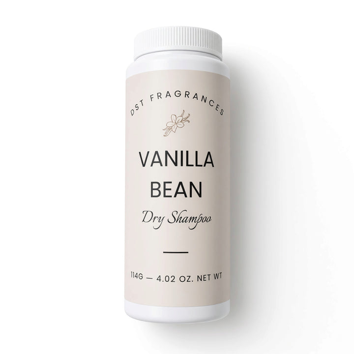 A white plastic bottle of DST Fragrances Vanilla Bean Dry Shampoo, featuring a light beige label with black text, set against a clean white background.