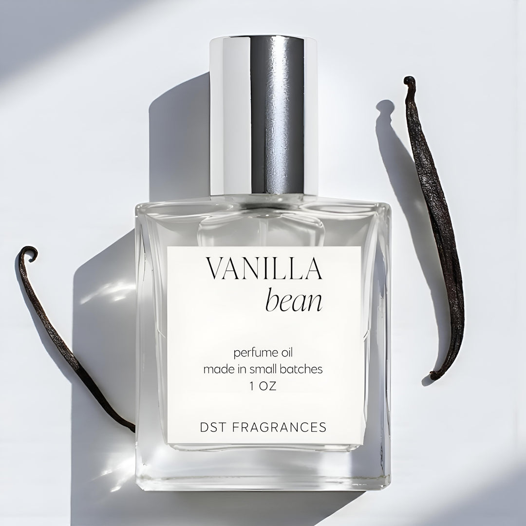 30ml bottle of Vanilla Bean scented Perfume Oil against ivory backdrop with vanilla beans in the background.