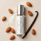 A bottle of Vanilla Vanilla perfume oil by Dst Fragrances, styled with whole almonds, a vanilla bean, and a cream-colored almond paste on a light beige background.