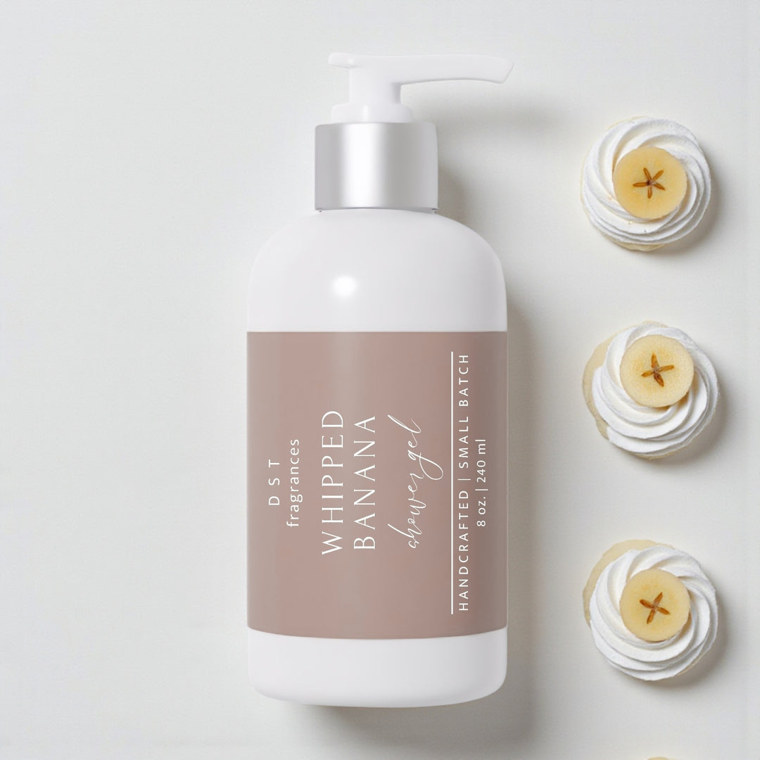 240ml bottle of Whipped Banana scented shower gel by DST Fragrances against a white background with sliced bananas on top of dollops of whipped cream.