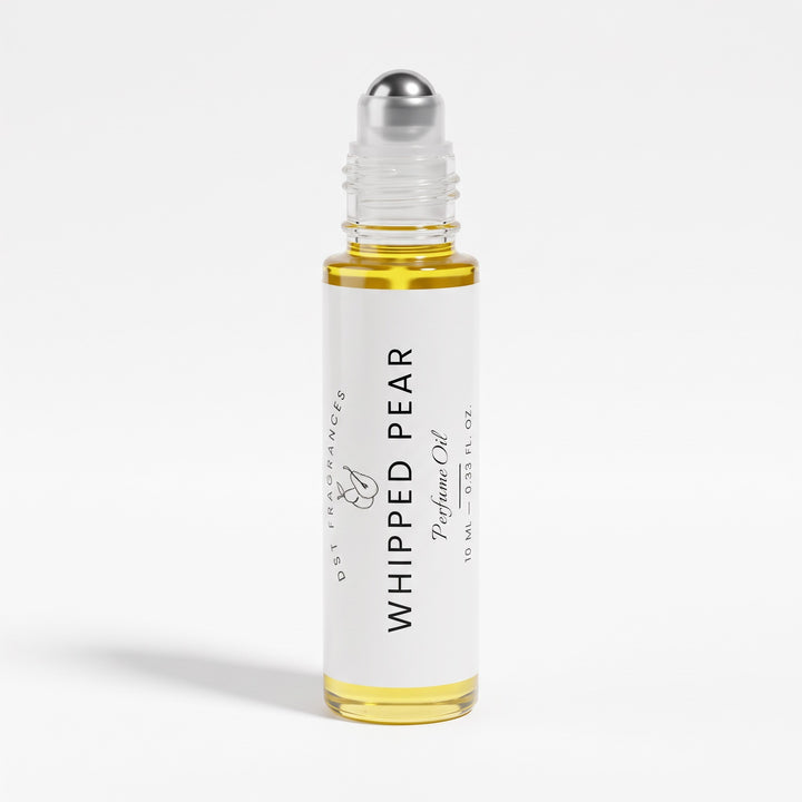 A 10 ml glass rollerball bottle of DST Fragrances Whipped Pear Perfume Oil, filled with golden-yellow oil and featuring a white label with black text, set against a clean white background.